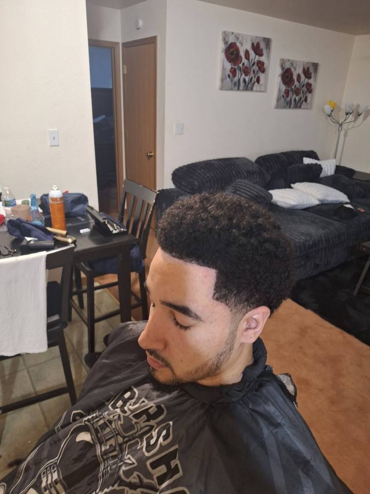 Curly top with a low taper and sharp temple line-up