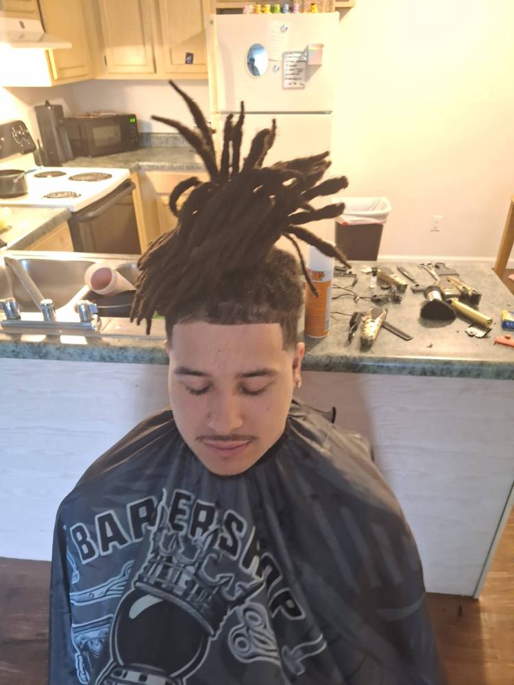Front view of locs in a high ponytail with a sharp line-up